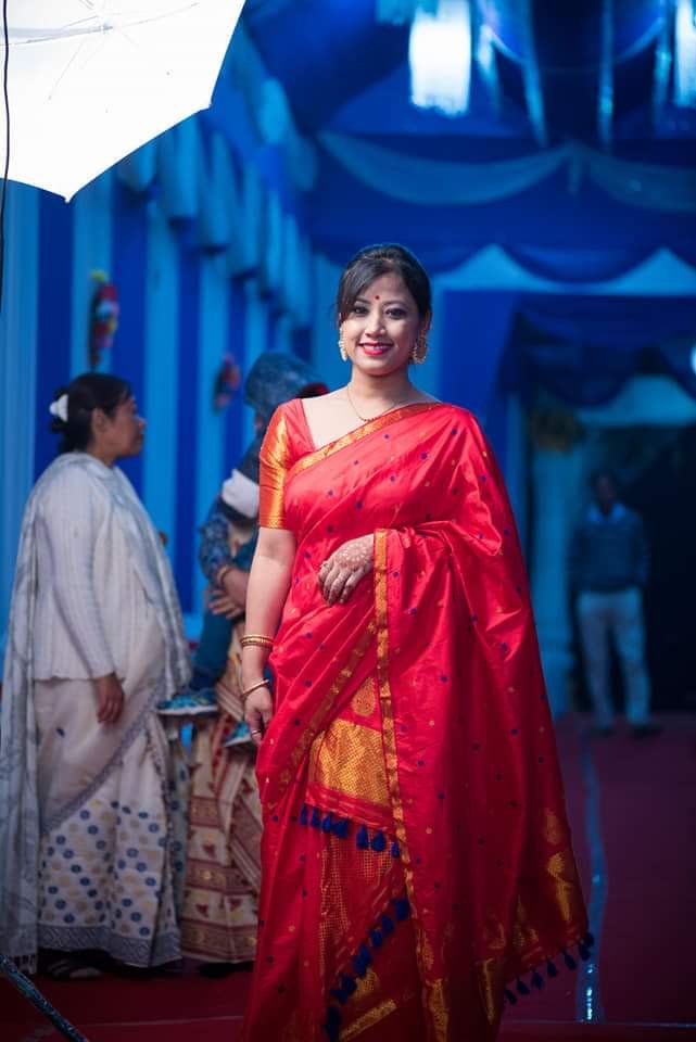 Assamese lady wearing red Paat Mekhela Sador